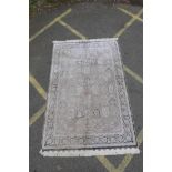 A pewter ground woven silk rug with a Persian panelled design with birds and flowers, 62" x 94"