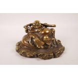 A Chinese bronze of Buddha seated on a sack, impressed mark to base, 7½" wide, 4½" high