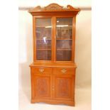 A good Victorian walnut bookcase, with two glazed doors and broken pediment with carved detail,