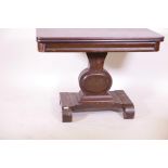 A C19th mahogany fold over tea table, raised on a shaped column on platform base with scroll feet,