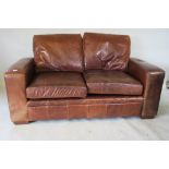 A two seater leather settee, 63" x 36"