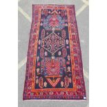 A red and blue ground Persian wool runner decorated with stylised birds and medallions, 46½" x 98"