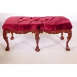 A mahogany window seat, with carved decoration, raised on six cabriole supports with ball and claw
