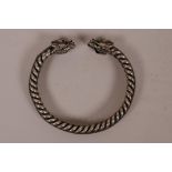 A Chinese silvered metal rope twist bangle with dragon head decoration to ends, 3" diameter