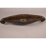 A Solomon Islands carved wood ceremonial bowl of boat shape with inlaid mother of pearl