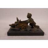 A bronze of a child pulling a toy cart, on a slate base, 6½" x 3½"