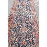 An antique Persian carpet/runner with a traditional medallion design on a blue field, 47" x 144"