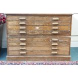 An early C20th pitch pine two section plan chest, with eight drawers, impressed with the Crown