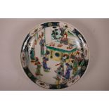 A Chinese famille verte porcelain charger decorated with figures in a court scene, 6 character