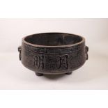 A large Chinese iron censer on tripod feet with two ring handles and character decoration, 13"