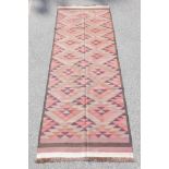 An antique Afghan Kilim rug decorated with a geometric design, 54" x 145"