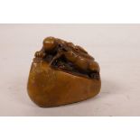 A Chinese soapstone seal with carved decoration of a kylin and flaming pearl, 2" wide