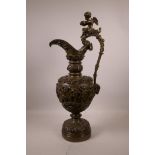 An Italian style bronze ewer adorned with putti, rams' masks and grapevines, 21½" high