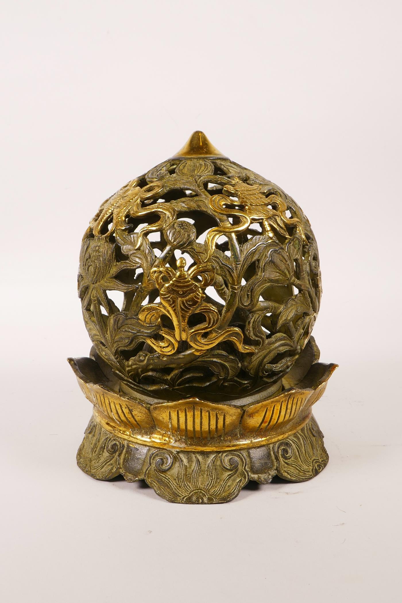 A Chinese pierced bronze ball censer decorated with the eight Buddhist treasures, highlighted with