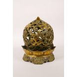 A Chinese pierced bronze ball censer decorated with the eight Buddhist treasures, highlighted with