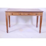 A mahogany two drawer writing table, with gadrooned edge and inset blind leather tooled top,