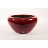 A Chinese flambé glazed pottery bowl with a rolled rim, 10" diameter