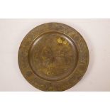 An Islamic brass dish on three copper supports, engraved with geometric designs