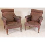 A pair of late C19th/early C20th easy chairs, with sprung upholstery and bolster backs, raised on