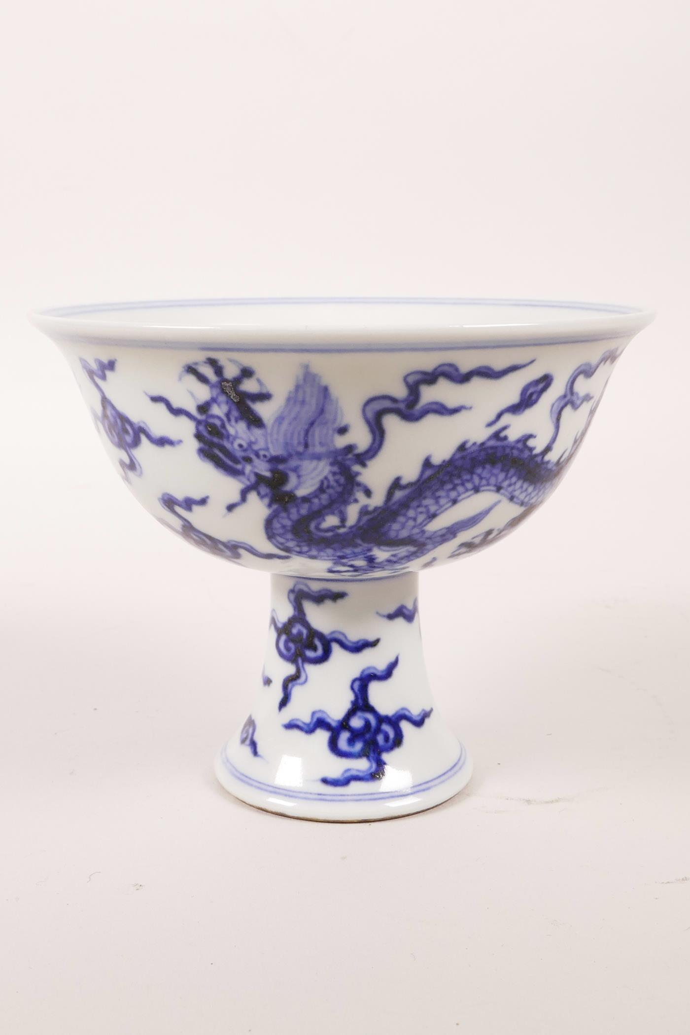 A Chinese blue and white porcelain stem cup decorated with two dragons chasing the flaming pearl,