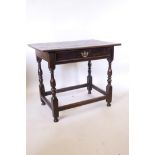 A C18th oak single drawer side table, raised on turned supports and united by stretchers, 33" x
