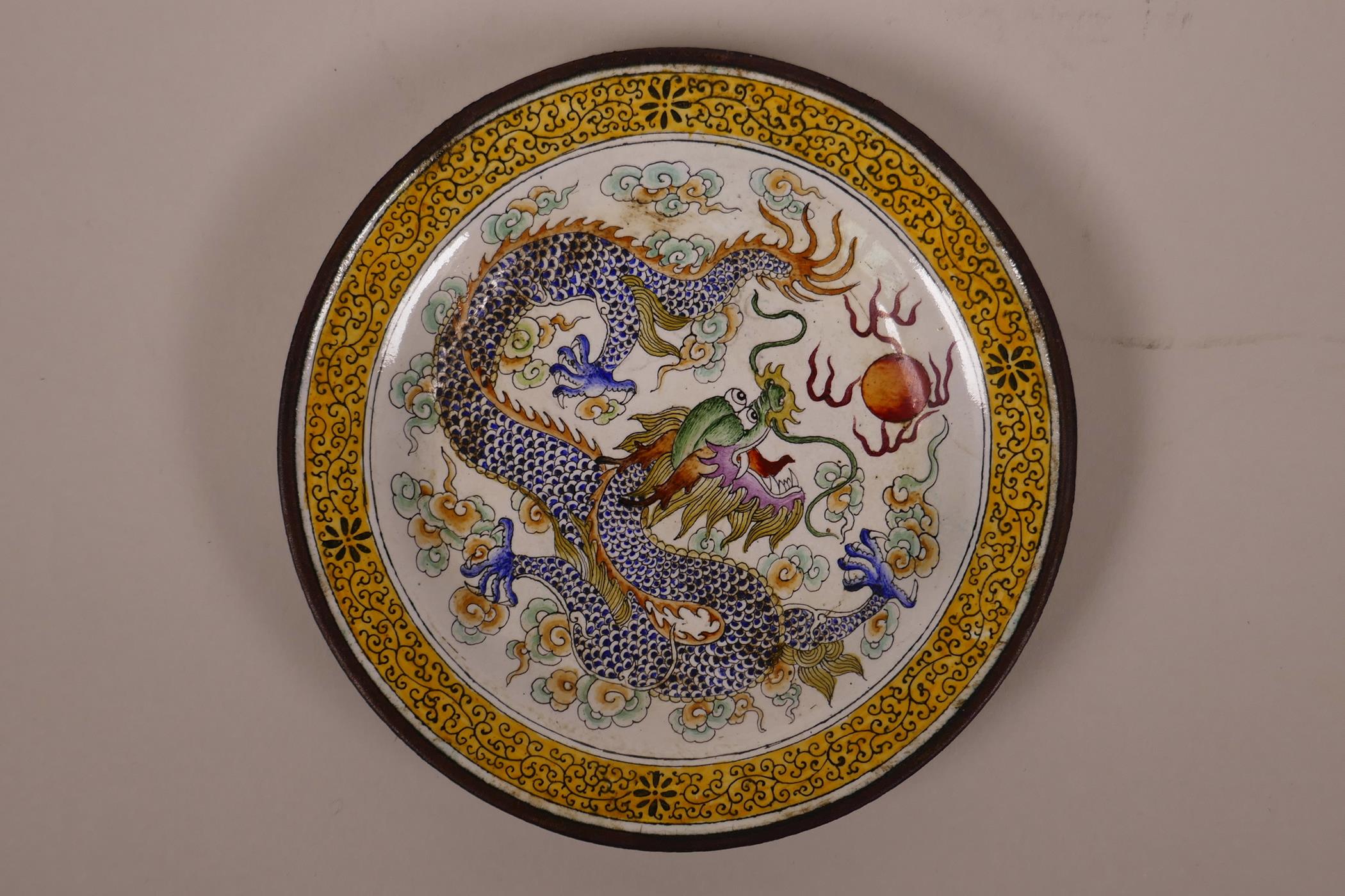 A Chinese Canton enamel saucer decorated with a dragon chasing the flaming pearl, 5¼" diameter