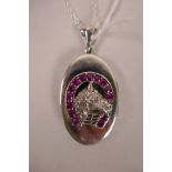 A 925 silver locket with applied horse head and shoe decoration set with ruby coloured stones, 2"