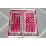 A pair of red ground Kashmir rugs with traditional Bokhara design, 26½" x 56"