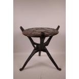 An African carved hardwood tripod stand with rhino and elephant decoration to the tray, 15" high