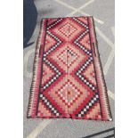 An antique Afghan Kilim rug decorated with geometric medallions, 108" x 60"