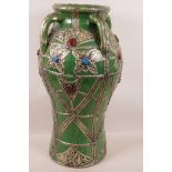 A large Indian green glazed pottery baluster base with four handles, the cased decoration with white