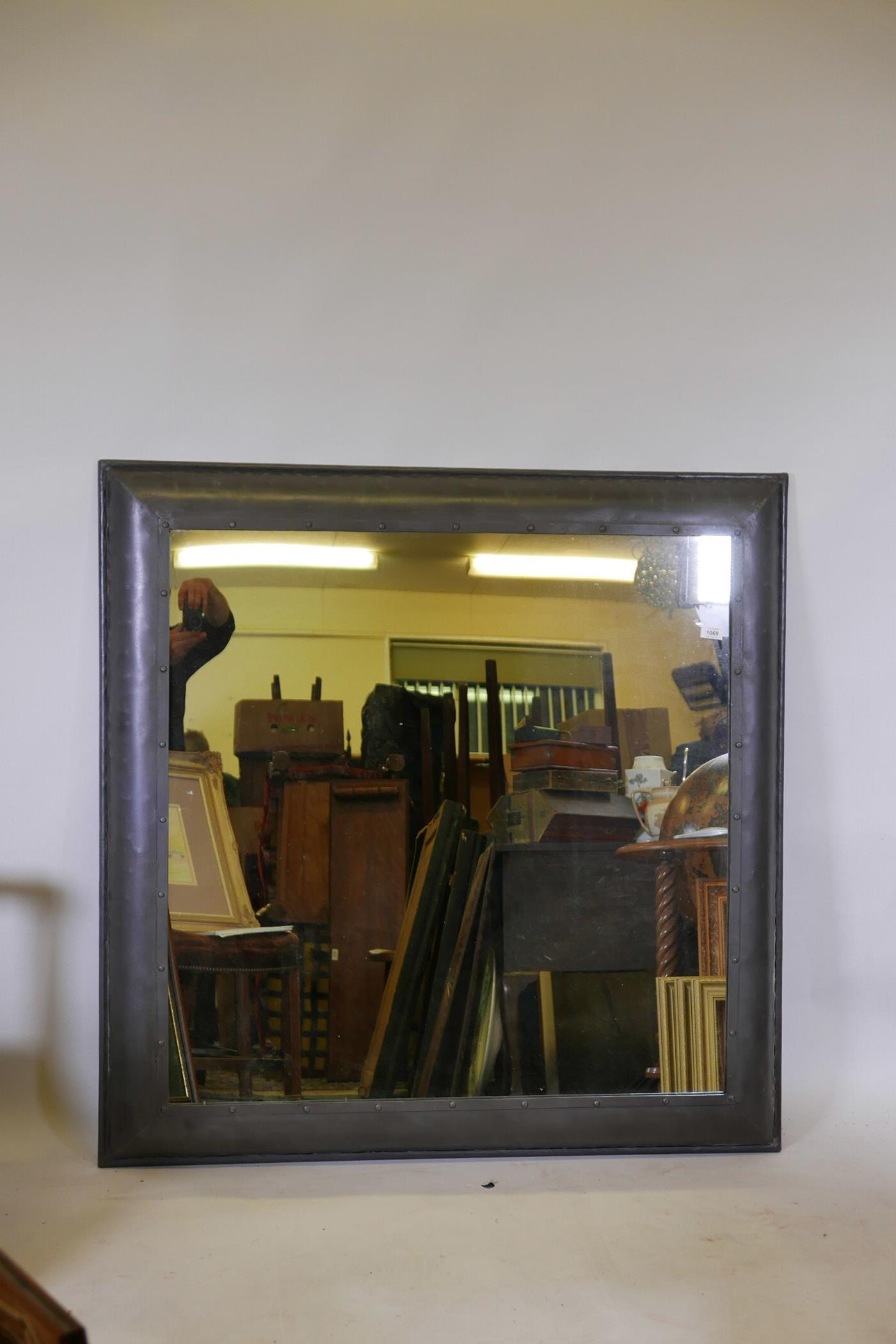 A large industrial steel framed wall mirror, 48" x 48"