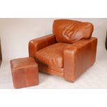 A contemporary leather armchair and matching pouffe, 40" x 40", 36" high