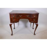 An early C20th Georgian style burr walnut five drawer kneehole desk, one leg requires refixing,