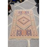 An antique Afghan Kilim rug with a central geometric medallion design, 73" x 107"