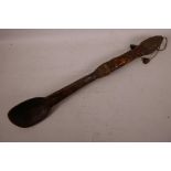 An antique tribal wooden spoon with a carved bone handle in the form of a crouching figure, iron