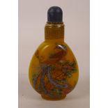 A yellow Peking glass snuff bottle decorated with an enamel dragon and phoenix, 3½" high