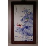 A large Chinese blue and white porcelain panel depicting lotus flowers with polychrome highlights to