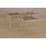A set of three metal framed glass top occasional tables with barred undertiers and brass finials,