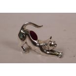 A novelty sterling silver pincushion in the form of a cat with peridot set eyes, 2" long