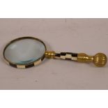 A brass handled magnifying glass with chequered bone decoration, 9½" long