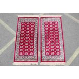 A pair of red ground Kashmir rugs with traditional Bokhara design, 26½" x 56"