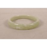 A Chinese mottled green jade bangle, 3" diameter