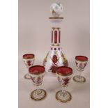 A Bohemian white cased red glass liquer set of decanter and four glasses, painted with flowers in