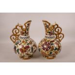 A pair of Austrian porcelain ewers by Jos Steidl Znaim, with Zsolnay style decoration, A/F, 9½" high