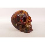 An amber style resin skull with esoteric decoration, 5" x 6½"