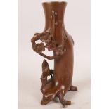 An Oriental coppered bronze spill vase in the form of a tree with a sage mounted on a donkey, 6"