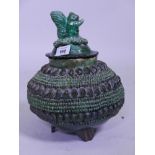 A slip glazed terracotta pot and cover with squirrel knop, 12" high
