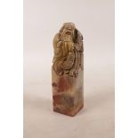 A Chinese soapstone seal with carved decoration of a fisherman to top, 4½" high