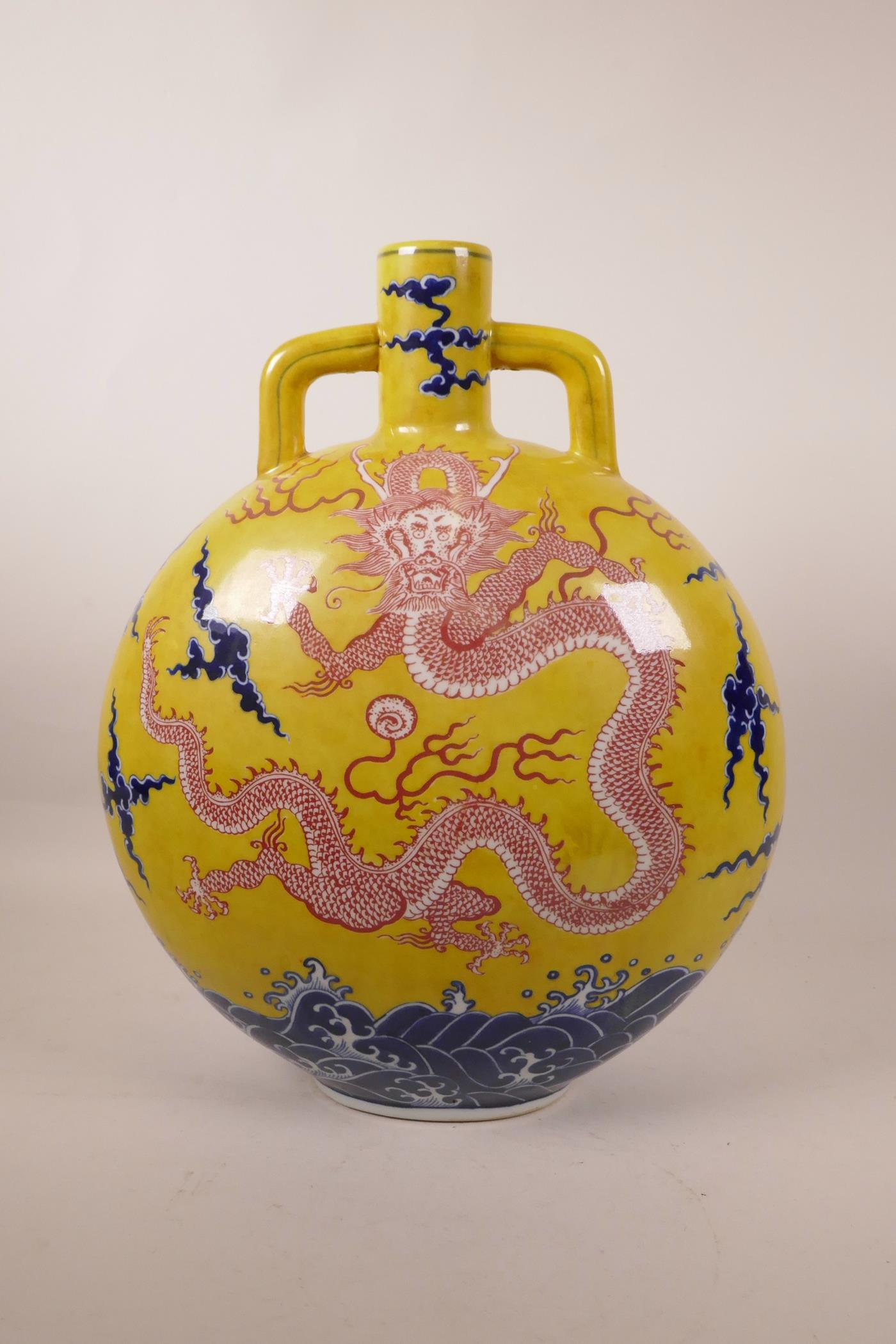 A large Chinese yellow ground moon flask with two handles decorated with a dragon chasing the